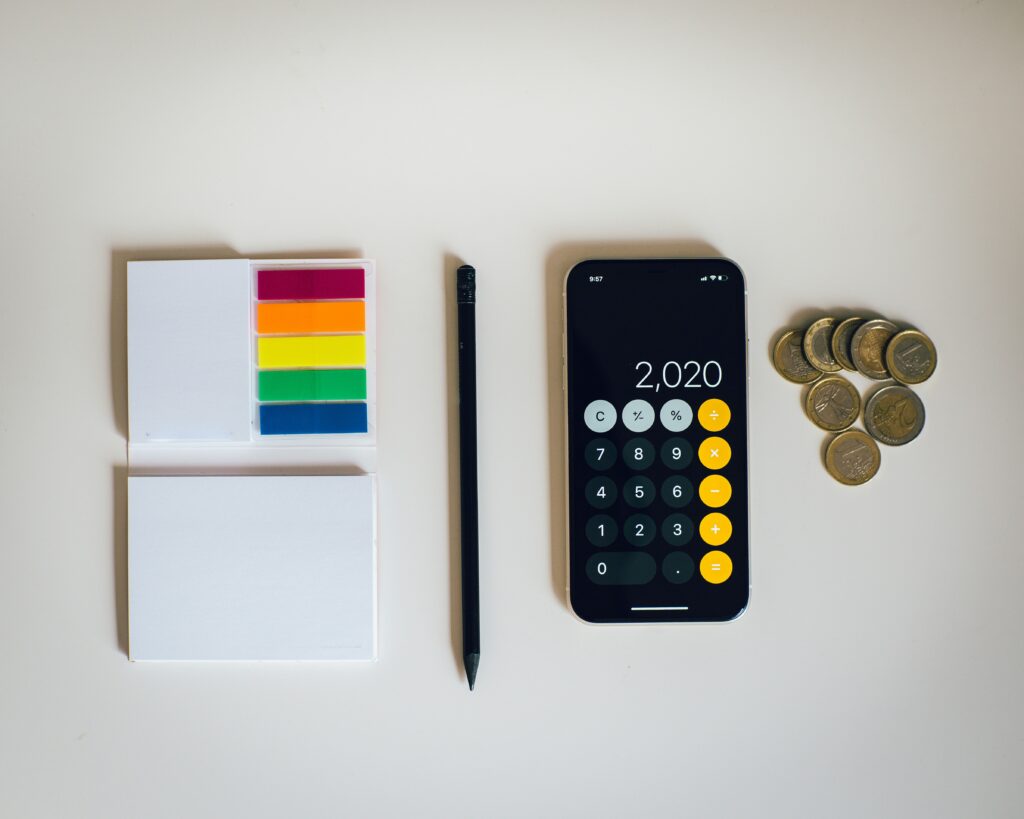 Calculator money and colour tags conveying different costs when buying a property